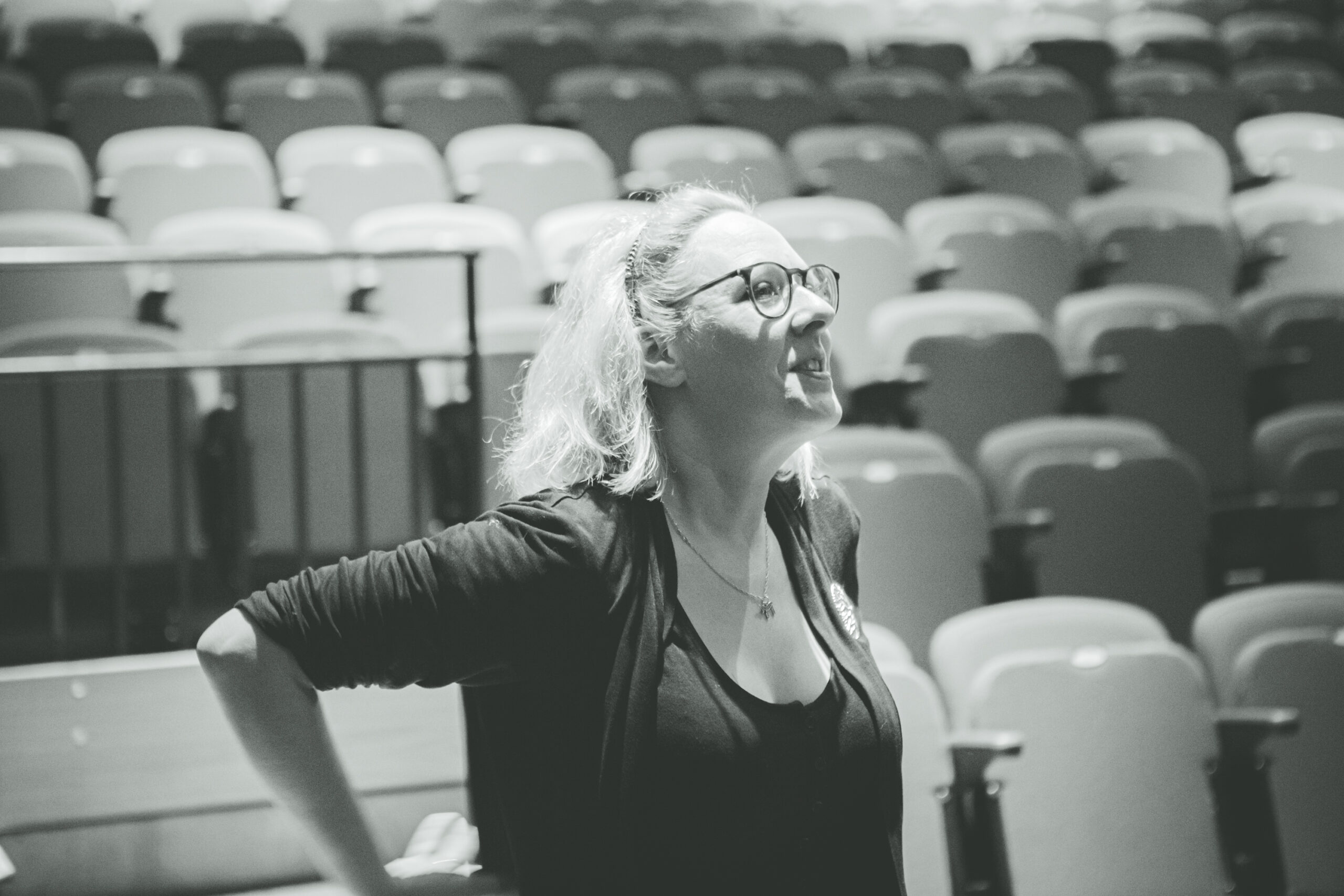 Black and white photo of artistic director, Cate Hollis, working on the rehearsals of the Kindness production